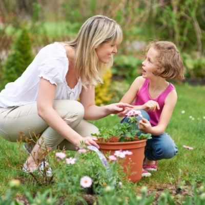 Pangera-Christa Lorenzi-Frau und Kind gärtnern